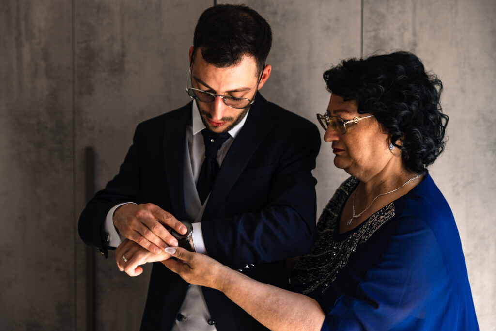 La mamma di Mirko sistema la giacca prima della cerimonia”