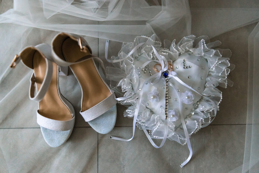 “Scarpe della sposa vicino alle fedi