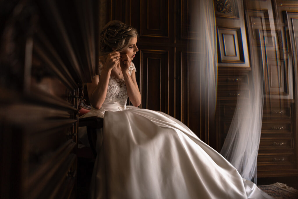 Dettaglio della sposa che si inserisce gli orecchini