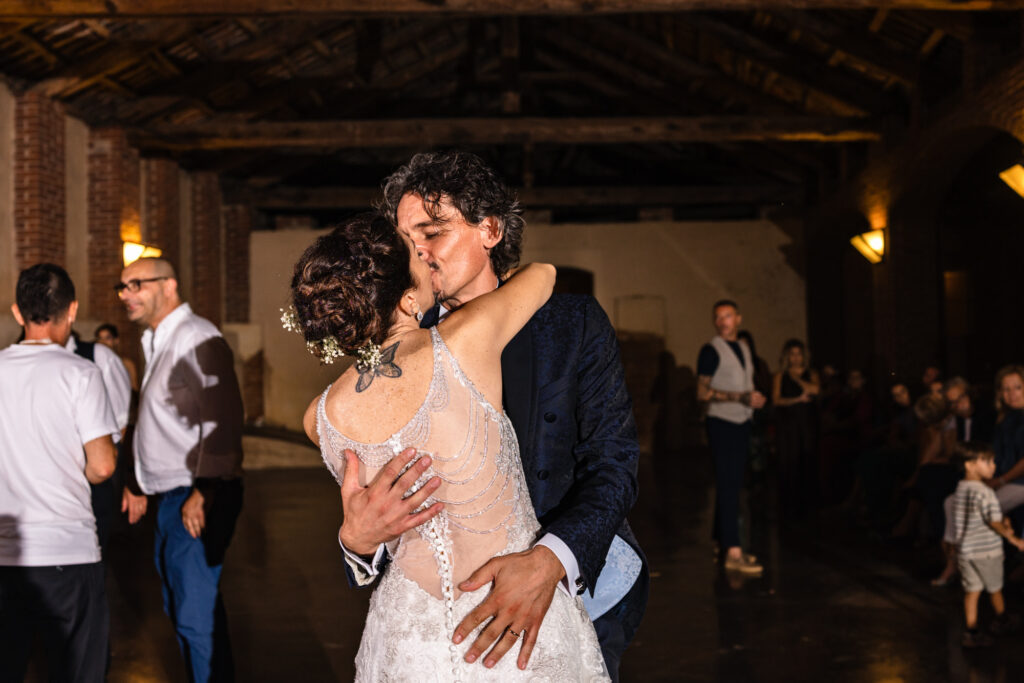 Un abbraccio e bacio degli sposi durante la festa 