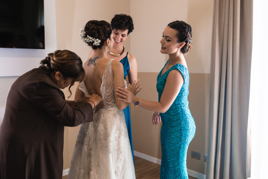 La mamma abbottona il vestito della sposa