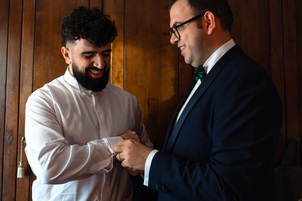 Il fratello dello sposo aiuta Emanuele a indossare i gemelli