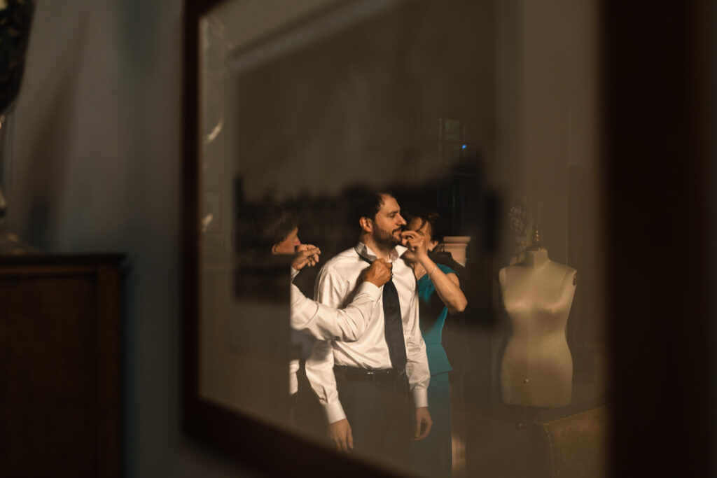 Dettaglio dello sposo mentre sistema la cravatta a Cherasco